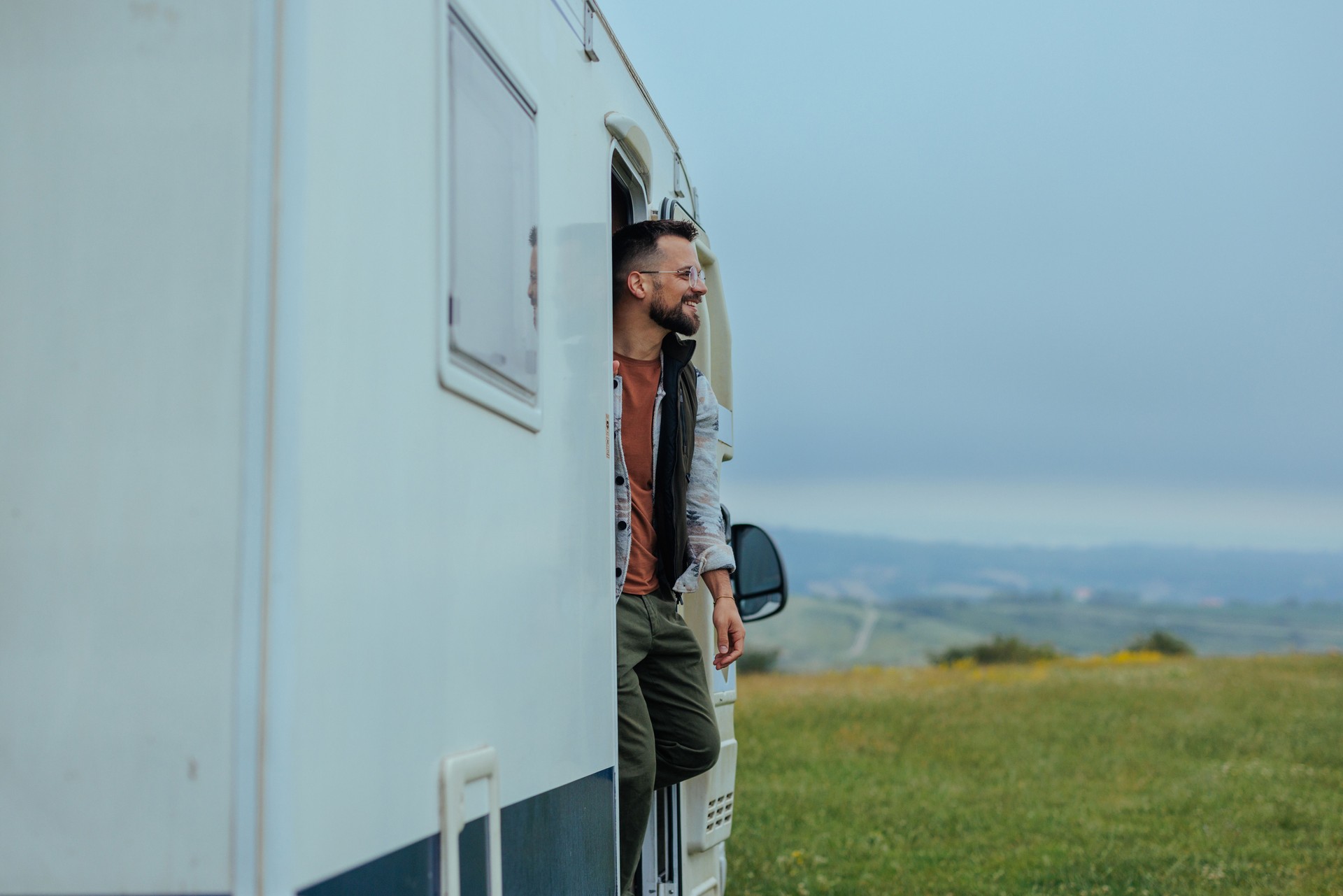 Man standing on the doors of a camper van